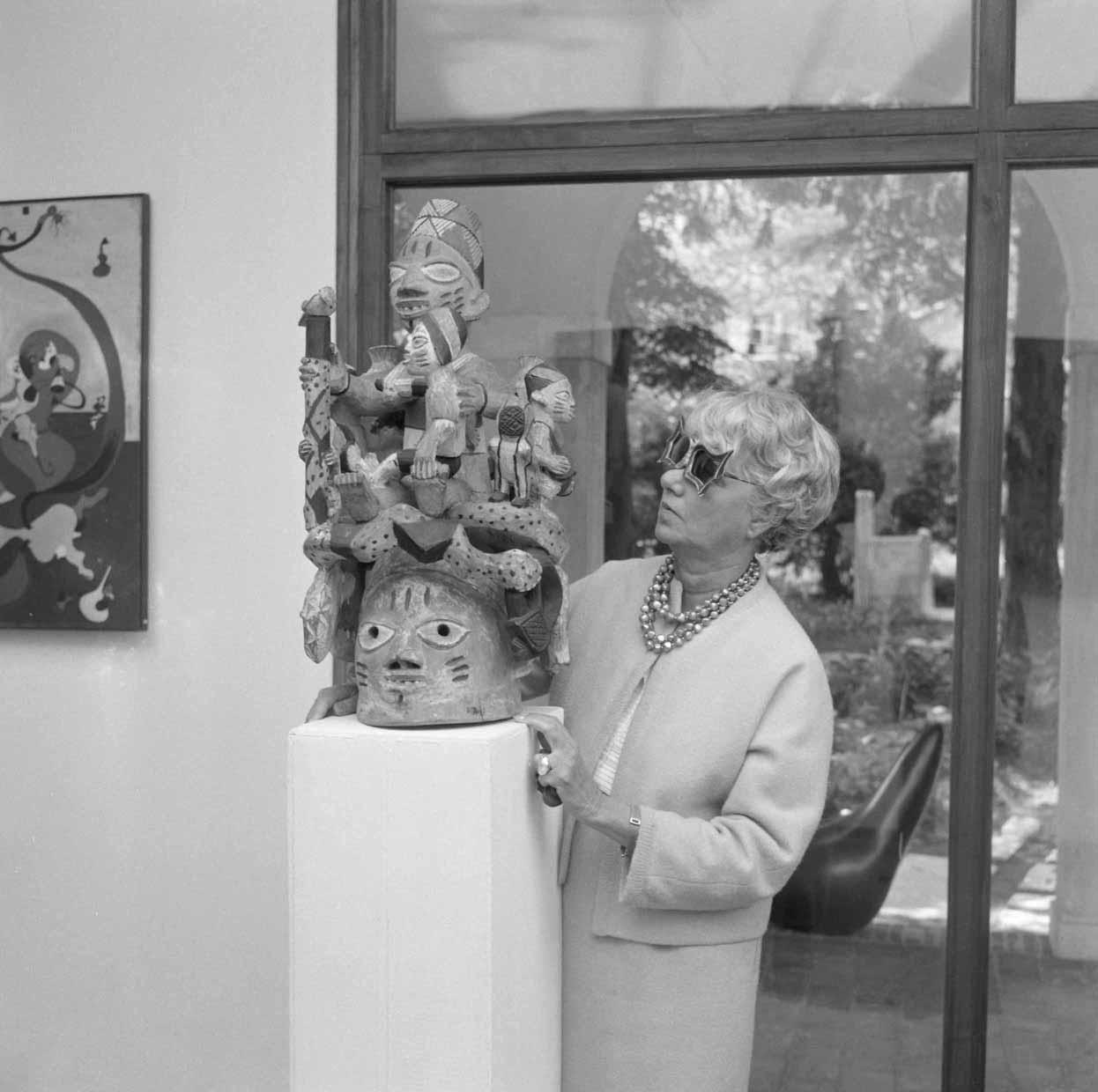 Peggy Guggenheim neben einer Skulptur ihrer Sammlung afrikanischer Skulpturen in Venedig, Ende der 60er Jahre.